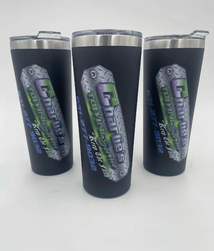 trio of sleek, black stainless steel tumblers customized with the 'Charlie's Towing' logo. These tumblers feature a metallic design with a holographic effect that catches light, highlighting the brand name and phone number.